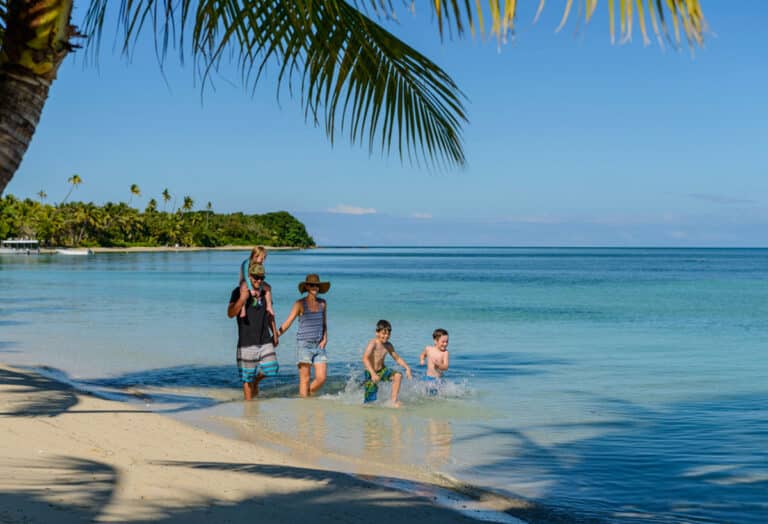 Plantation Island Resort Fiji - Family walking in shallow waters beachfront