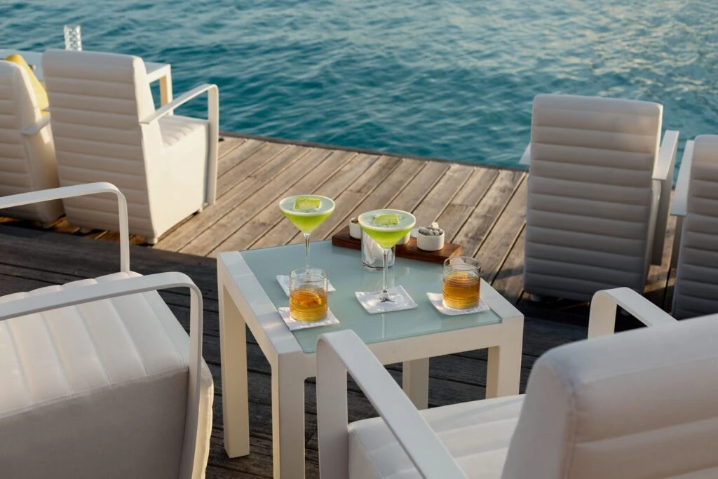 Deck of an overwater villa at The St. Regis Bora Bora with drinks and the lagoon beyond