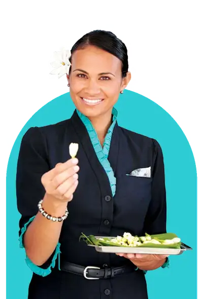 Smiling Air Tahiti Nui flight attendant offering a tiare flower